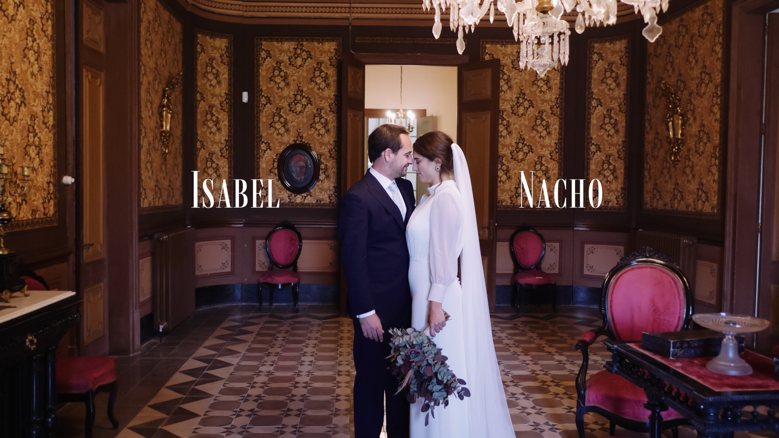 Pareja de novios en el salón de un palacio, compartiendo un momento romántico en su elegante boda bajo arañas de cristal. En la La Torre de Can Parellada, Barcelona