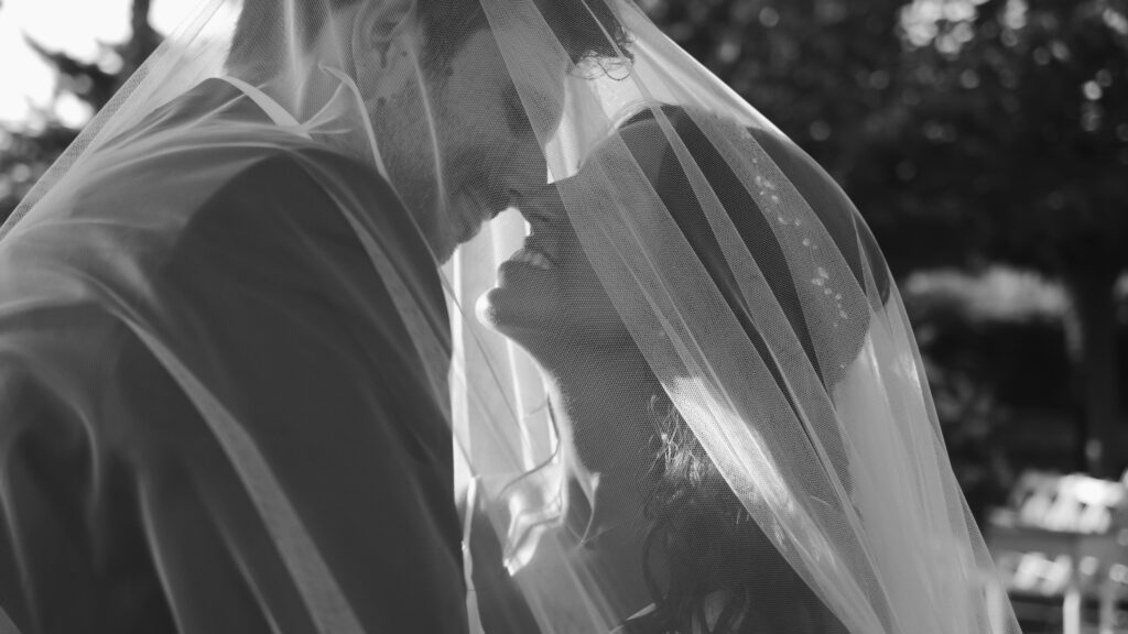 Primer plano en blanco y negro de la cara de una pareja, con el velo de la novia creando un efecto suave y romántico. En la masia Turó del Sol