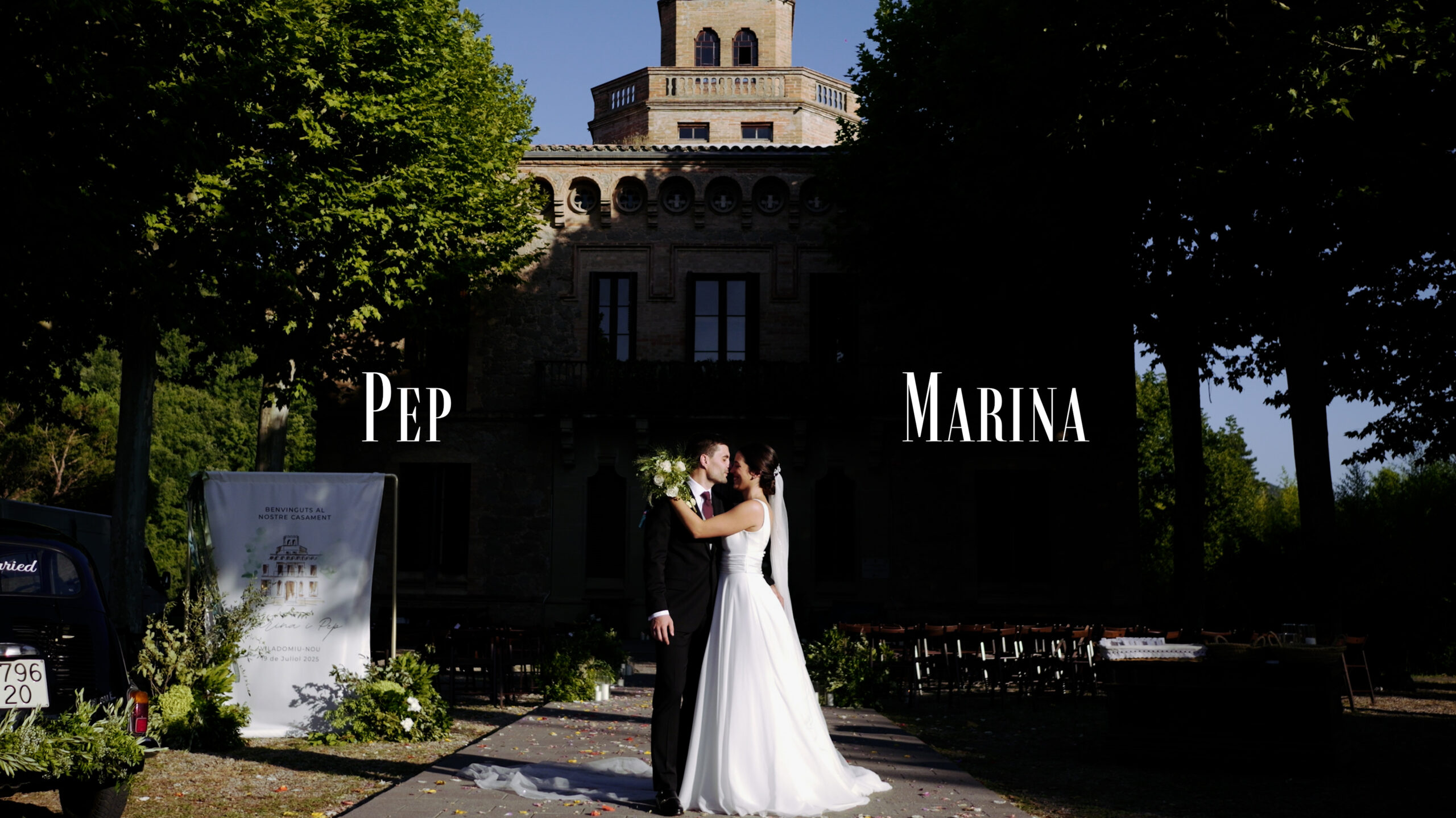 Novios frente a la Torre de l'Amo de Viladomiu Nou durante un vídeo de boda cinematográfico.